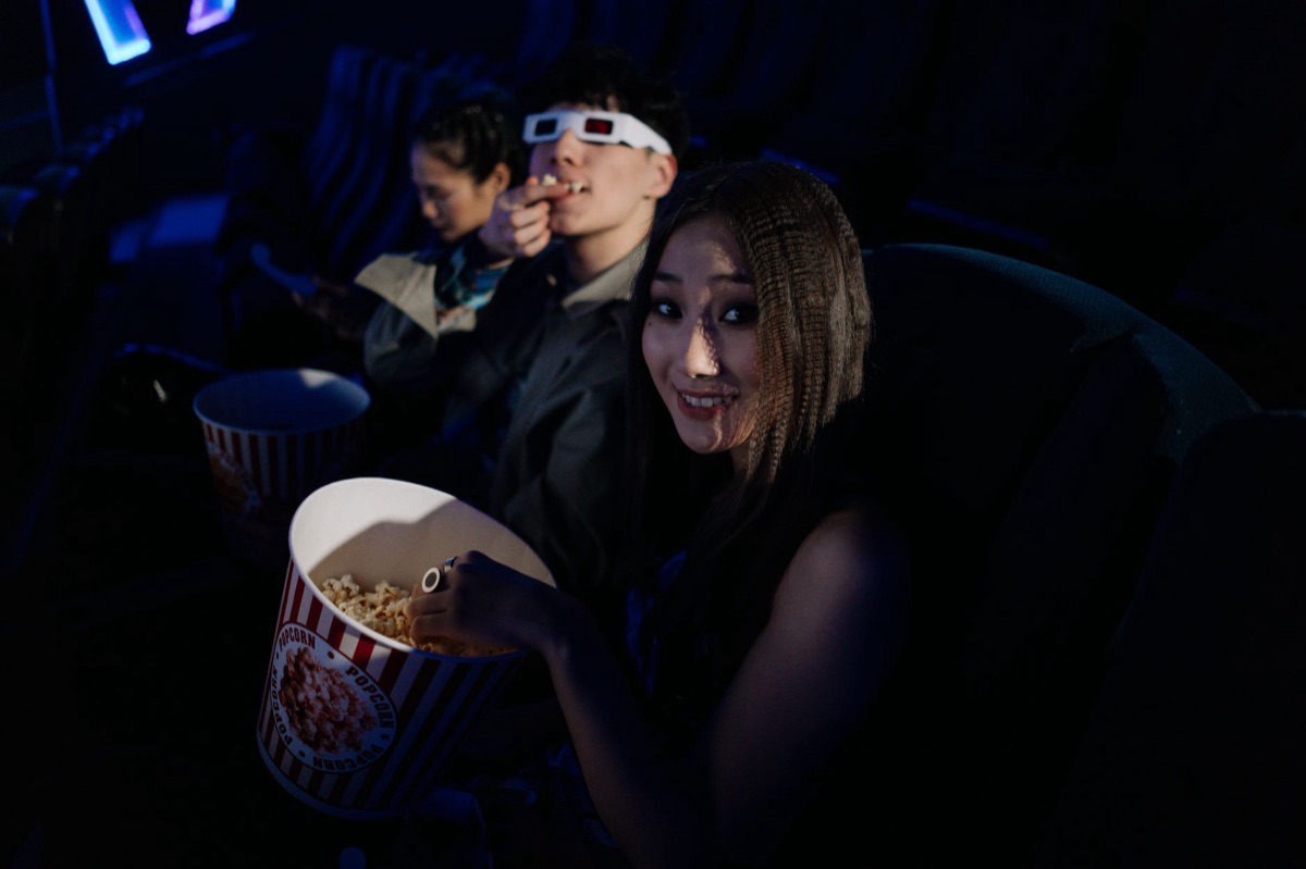 Kinokarten und Popcorn vor Anime-Postern.