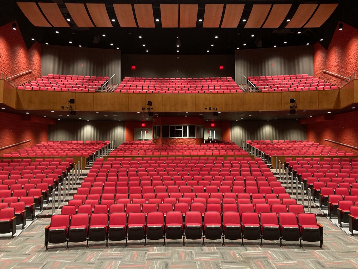 Een lege theaterbühne met een felle spotlight.