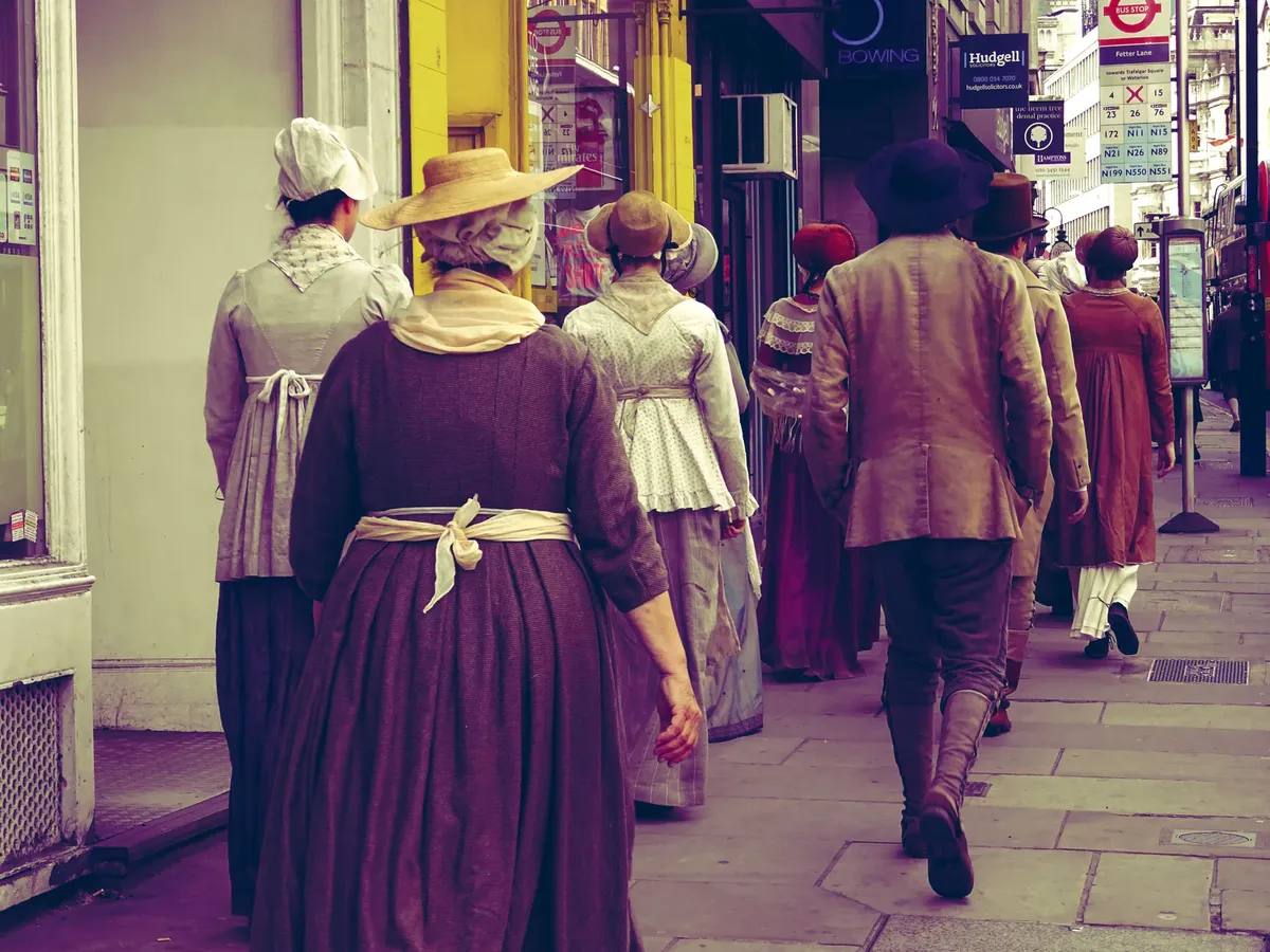 People in historical costumes walking on a city street, evoking a vintage ambiance.