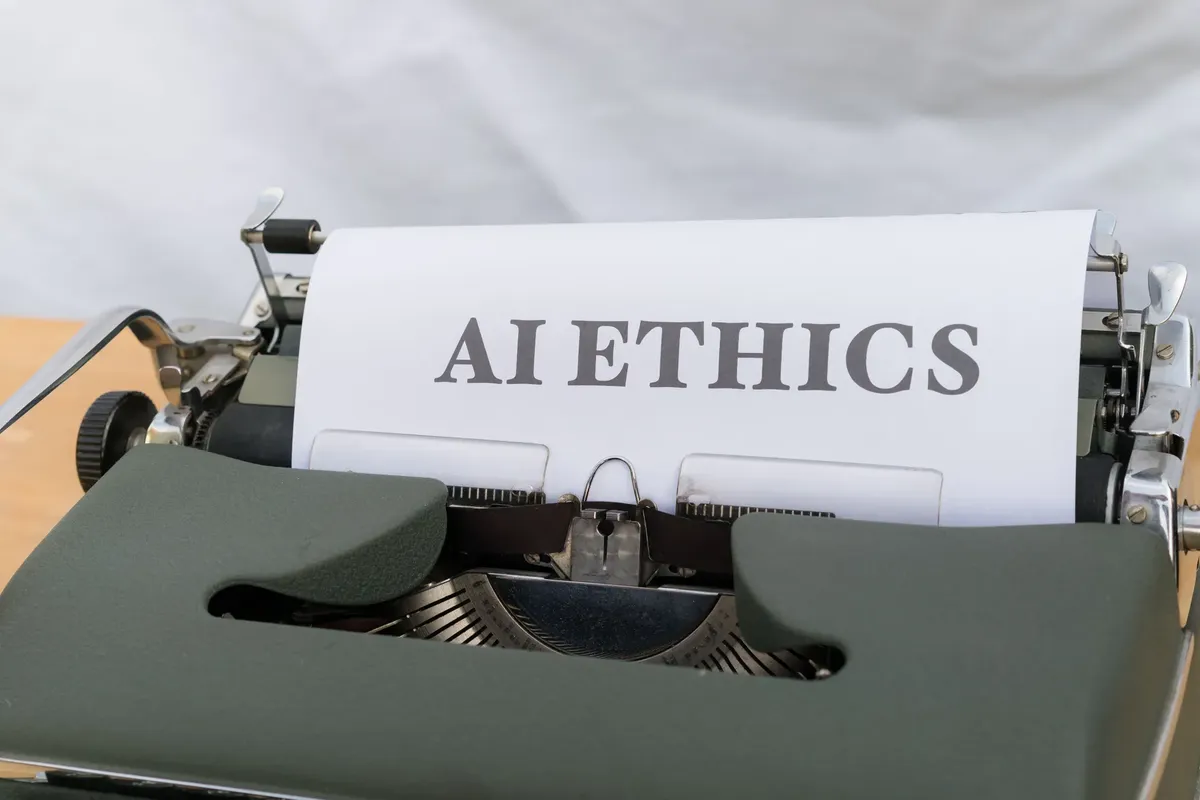Close-up of vintage typewriter with 'AI ETHICS' typed on paper, emphasizing technology and responsibility.