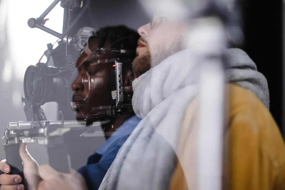 Close-up of a film crew capturing a scene with professional equipment, showcasing teamwork and creativity.