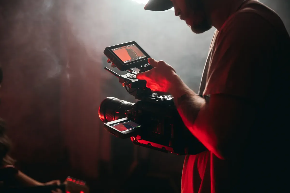 A cinematographer filming on set using professional camera gear, capturing a cinematic scene.